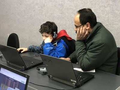 a student and parent on computers